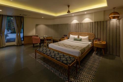 a hotel room with a bed and a table at Indus Suites in Nagpur
