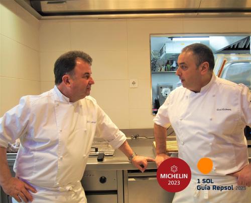 two men are standing in a kitchen at Hotel Tayko Bilbao in Bilbao