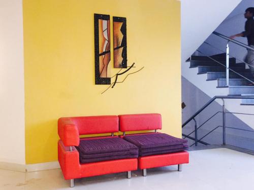 a red bench in a room with a painting at Octave Hotel & Spa - Marathahalli in Bengaluru