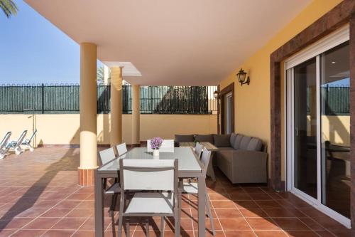 d'une terrasse avec une table, des chaises et un canapé. dans l'établissement Villa esclusiva a 1 chilometro da Playa de Los Cristianos, à Los Cristianos