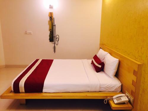 a bed in a room with a phone next to it at Octave Hotel & Spa - Marathahalli in Bengaluru