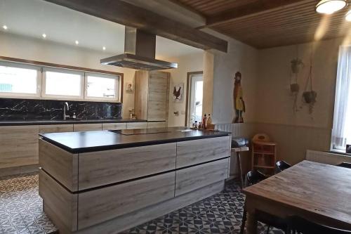 a large kitchen with a large island in the middle at Hoeve Korenzegen. Oase van rust dichtbij strand in De Haan