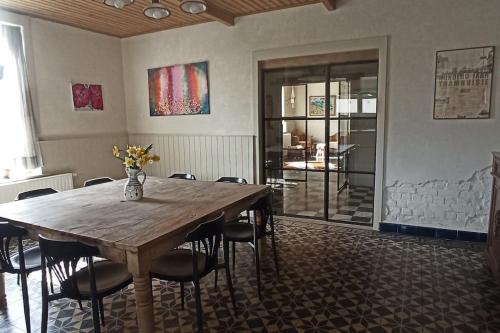 a dining room with a wooden table and chairs at Hoeve Korenzegen. Oase van rust dichtbij strand in De Haan