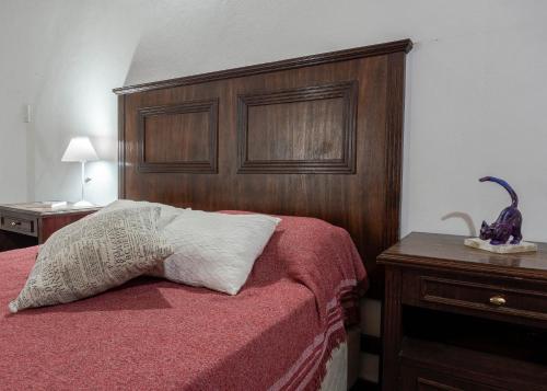 a bedroom with a bed with a wooden head board at Complejo Yaguareté in Corrientes