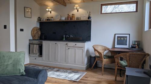 a living room with a couch and a table at A Somerset Countryside Lodge in Holcombe