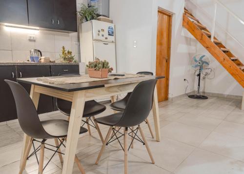 a kitchen with a wooden table and chairs at Complejo Yaguareté in Corrientes