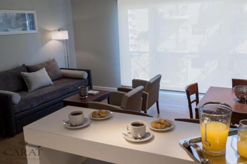 a living room with a couch and a table with food at Hotel Carat Apart Boutique in Rosario