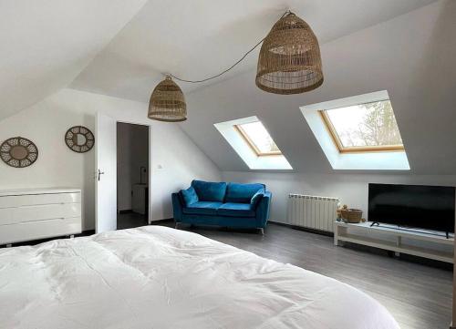 1 dormitorio con 1 cama y 1 silla azul en Le 90 - Grande maison cosy, en Isneauville
