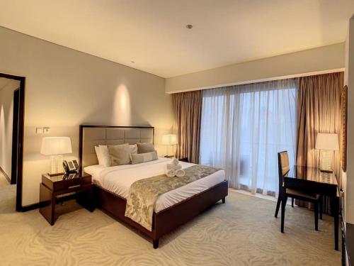 a large hotel room with a bed and a desk at Key View - Emaar Residences, Marina Mall in Dubai