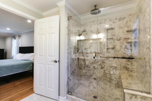 Baño con ducha a ras de suelo junto a una cama en Connecticut Vacation Home Rental with Private Pool! en Southington