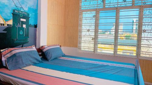 um quarto com uma cama e uma janela com vista em Biyu’s Cozy House 2 em Hanói