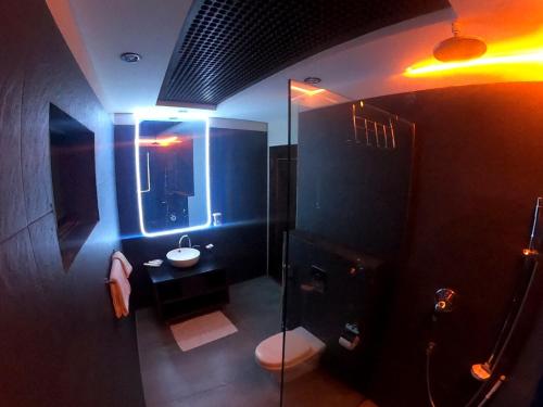 Baño oscuro con aseo y lavamanos en Rockville House managed & operated by Serai Boutique Hotels and Resorts en Islamabad