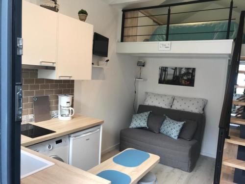 un petit salon avec un canapé et une cuisine dans l'établissement Charmant Studio avec Terrasse et Parking - 4 Pers - Arcachon - FR-1-474-161, à Arcachon