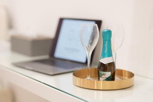 uma garrafa de champanhe num suporte ao lado de um computador portátil em I Mori dell’Etna em Giardini Naxos