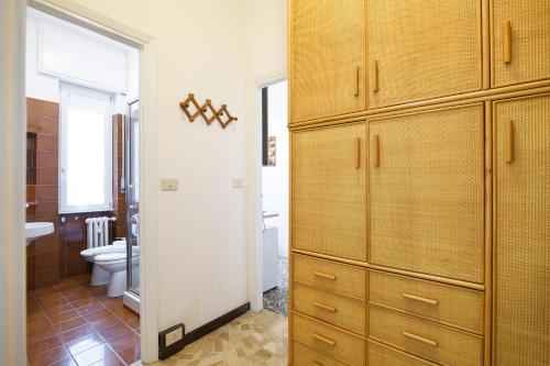 łazienka z dużą drewnianą szafką i toaletą w obiekcie PrimoPiano - Romilli w Mediolanie