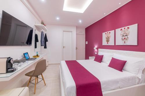 a bedroom with a large bed with a purple wall at I Mori dell’Etna in Giardini Naxos