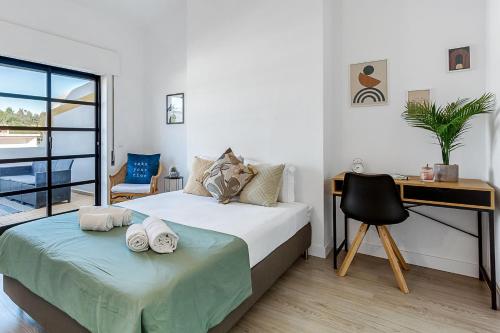 a bedroom with a bed and a desk and a chair at Sunny Duplex W/ Pool & Balcony by LovelyStay in Carvoeiro