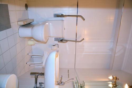 a bathroom with a shower with a toilet and a sink at Hotel Termas in Chaves