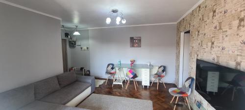 a living room with a couch and a table with chairs at Comfort Home Apartment 1 in Petroşani