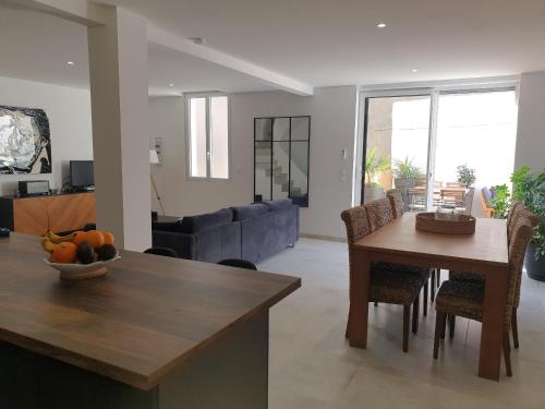 une cuisine et un salon avec une table et un canapé dans l'établissement Maison de ville standing proche mer, à Florensac