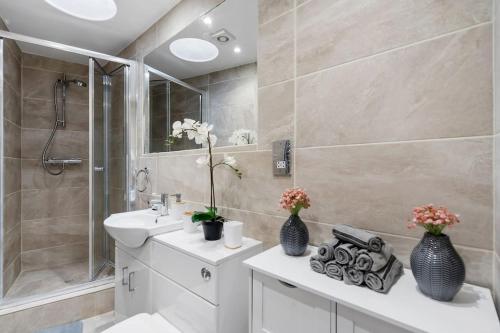 a bathroom with a white sink and a shower at Charming Cottage in Hampstead Heath in London
