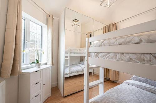 a bedroom with a bunk bed and a mirror at Charming Cottage in Hampstead Heath in London