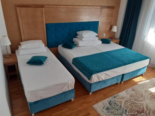 2 camas en una habitación de color azul y blanco en Hotel Club Bucovina Resort & Spa en Gura Humorului