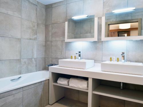 a bathroom with two sinks and a bath tub at Appartement Courchevel 1550, 2 pièces, 4 personnes - FR-1-562-52 in Courchevel