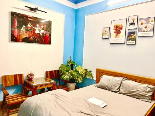 1 dormitorio con 1 cama, mesa y sillas en Nhà nghỉ Thành Trung, 