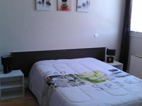 une chambre avec un lit et deux tables de nuit dans l'établissement **Appartement T3 Centre-Ville La Roche-Posay avec Piscine, Terrasse et Wi-Fi** - FR-1-541-74, à La Roche-Posay