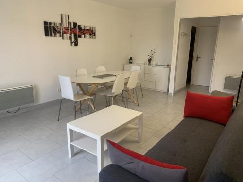 ein Wohnzimmer mit einer Couch und einem Tisch und Stühlen in der Unterkunft Appartement T3 en Centre-Ville de La Roche-Posay avec Terrasse, Piscine et Parking - FR-1-541-75 in La Roche-Posay