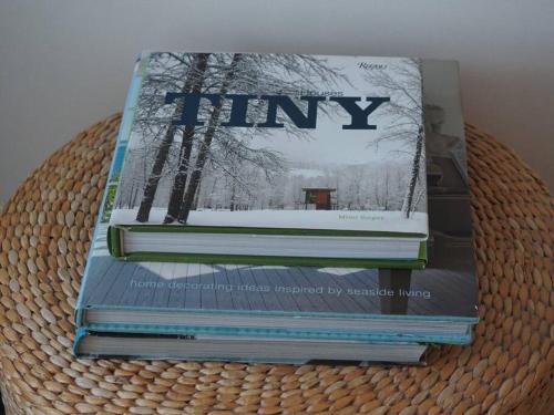 a stack of books sitting on top of a basket at The little post house. A perfect village retreat, with stunning views. in Boscastle