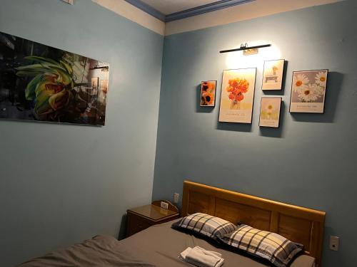 1 dormitorio con 1 cama y cuadros en la pared en Nhà nghỉ Thành Trung, 