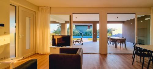 a living room with a television and a dining room at Ville Lazise Ada & Rico in Lazise