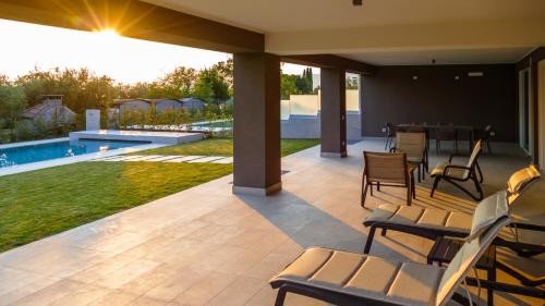 a patio with chairs and a swimming pool at Ville Lazise Ada & Rico in Lazise