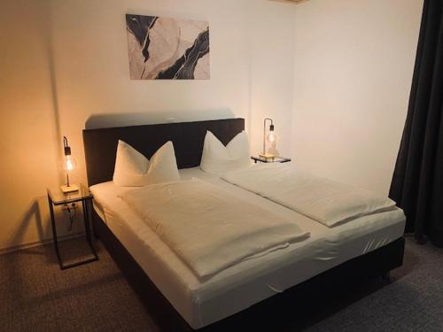ein Schlafzimmer mit einem großen Bett mit zwei Leuchten in der Unterkunft Landgasthof Brandtner Wirt in Langdorf