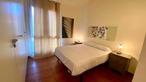 a bedroom with a bed and two lamps on a night stand at Acogedor apartamento con altillo MSJ 53 in Calafat