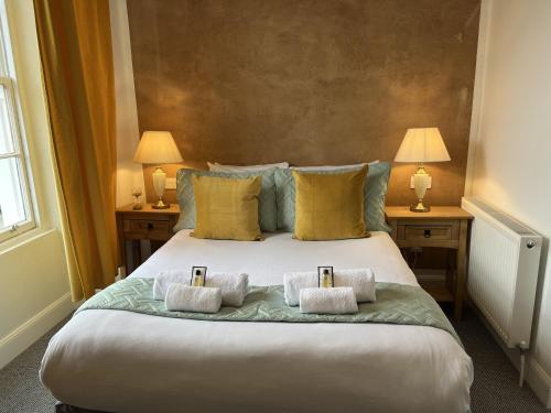 a bedroom with a large bed with three pillows at Royal Suites Kirkcudbright in Kirkcudbright