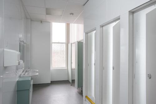 a white bathroom with a sink and a mirror at McIntosh Hall Campus Accommodation in St Andrews