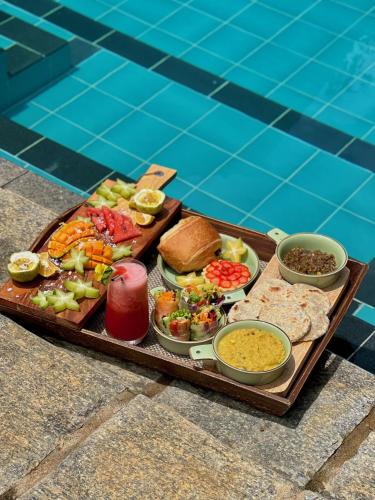 a tray of food on a table next to a pool at The Jungle Loft Galle in Galle