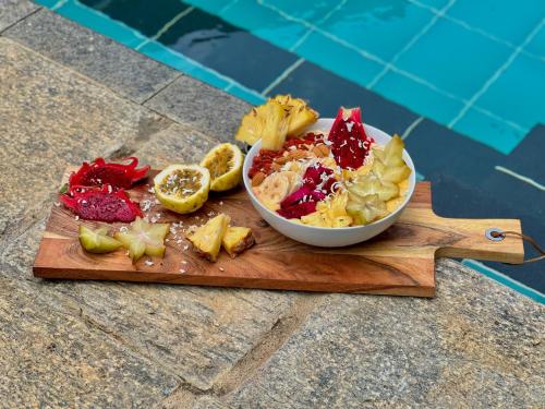 a bowl of fruit and vegetables on a cutting board at The Jungle Loft Galle in Galle