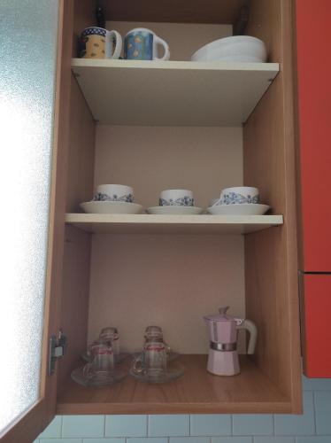 un armadio con tazze e piattini di TamarHouse Sperlonga Casa Naila a Sperlonga