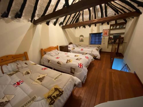 three beds in a room with wooden floors at Cabaña con excelente ubicación y zona verde. in Iza