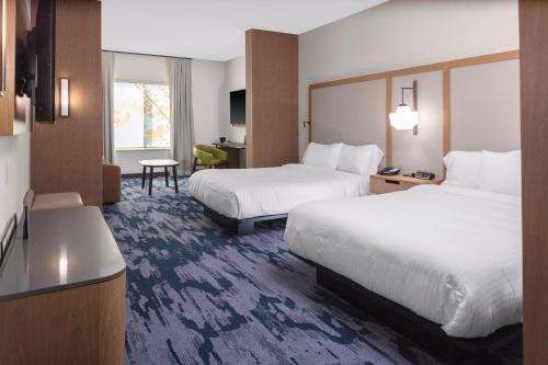 a hotel room with two beds and a desk at Fairfield Inn & Suites by Marriott Corinth South Denton Area in Corinth