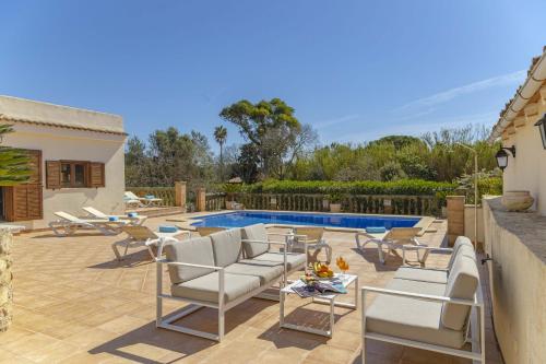 a patio with chairs and a swimming pool at Villa Sa Font / Les Cases de la Font in Pollença