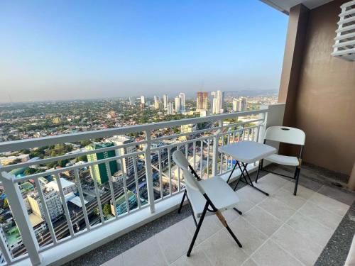 a balcony with chairs and a view of a city at Infina Towers Affordable staycation in Manila