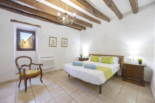 a bedroom with a large bed and a chair at Villa Sa Font / Les Cases de la Font in Pollença