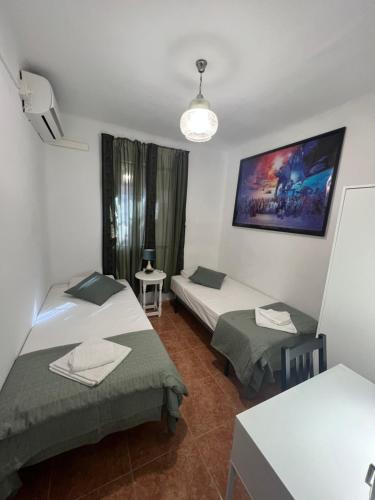 塞維利亞的住宿－Fresh & Clean Room Sevilla，一间设有两张床和一张桌子的房间