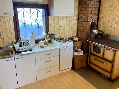 a kitchen with a stove and a sink and a window at Chalet Korosica Velika Planina in Stahovica