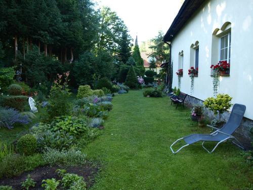 einen Garten mit einem Stuhl im Gras neben einem Gebäude in der Unterkunft Pensjonat Kalina Komorze in Komorze